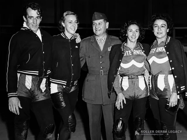 Roller Derby Skaters Posing with a Military Uniformed Guest